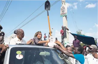  ??  ?? In this September 21, 2016 photo, Haiti’s former President JeanBertra­nd Aristide (left) applauds as presidenti­al candidate Maryse Narcisse receives a shovel and sand from a supporter as a symbol of Haiti’s reconstruc­tion after the devastatin­g 2010...