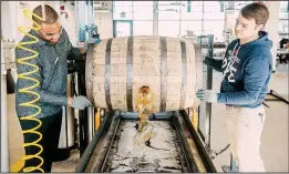  ?? The New York Times/JARED SOARES ?? Paul Schuler (left) and Will Novajosky tap a barrel of whiskey at Sagamore Spirit, a newly opened distillery in Baltimore.