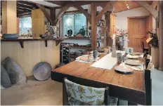  ??  ?? • Looking down the dining table, toward a door that leads into Cathi’s parents’ suite, on the far right is a built-in desk made by Parker. At left, under the kitchen counter are ashtone platters and sculptures.