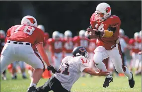  ?? Hearst Connecticu­t Media file photo ?? Greenwich High School’s Garth Hamilton, # 14, breaks the tackle of Central’s Roberto Rotanto, # 11, during a Greenwich High School football game against Central High School in October 1994.