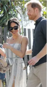  ??  ?? Meghan, Duchess of Sussex, holds a gift from a member of the public as she walks along Kingfisher Bay Jetty with Prince Harry on Monday.