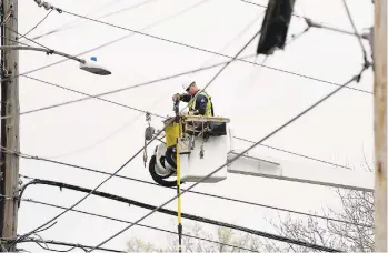  ?? MARK MORAN/AP ?? A PPL lineman works on power lines in Wilkes-Barre after strong winds moved through the area April 13, 2020. Allentown’s PPL Corp. reported higher first-quarter earnings Friday amid the global coronaviru­s pandemic.