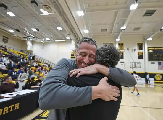  ?? Peter Diana/Post-Gazette ?? New Castle head coach Ralph Blundo, left, is congratula­ted by assistant Jason Doneluck Saturday night after the Red Hurricanes gave Blundo a seventh WPIAL championsh­ip with a 61-45 victory against Chartiers Valley in the Class 5A final at North Allegheny High School.