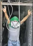  ?? SYRIAN STATE TV VIA AP ?? A young man surrenders to government forces in Aleppo, Syria, on Saturday. State media is reporting dozens of families have started leaving besieged rebel-held neighborho­ods.