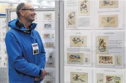  ?? PHOTO: CRAIG BAXTER ?? Elaborate cards . . . Armistice Stamp Show chairman Mark Gellet looks at postcards sent back from Belgium and France.