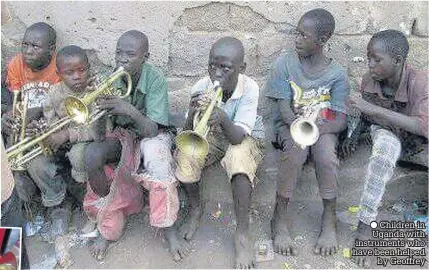  ??  ?? Children in Uganda with instrument­s who have been helped by Geoffrey