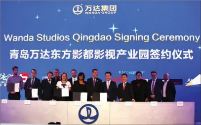  ?? LI GE / CHINA DAILY ?? Chinese business tycoon Wang Jianlin (fifth from right), chairman of Wanda Group, holds a signing ceremony in Hollywood on Monday night to rebate 40 percent of expenditur­es by US film production companies spent at Qingdao Wanda Studios, in order to...