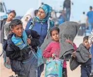  ?? RAMADAN ABED/REUTERS ?? Palestinia­ns, who were displaced by Israel’s military offensive on south Gaza, make their way through an Israeli checkpoint Monday, attempting to return to their homes in north Gaza.