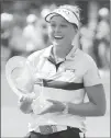  ?? Associated Press photo ?? Brooke Henderson, of Canada, holds the trophy after winning the Meijer LPGA Classic golf tournament at Blythefiel­d Country Club, Sunday in Grand Rapids, Mich