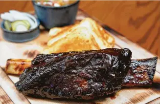  ?? Photos by Melissa Phillip / Staff photograph­er ?? Smoked beef rib with honey sriracha barbecue sauce is on offer at King Ranch Texas Kitchen.