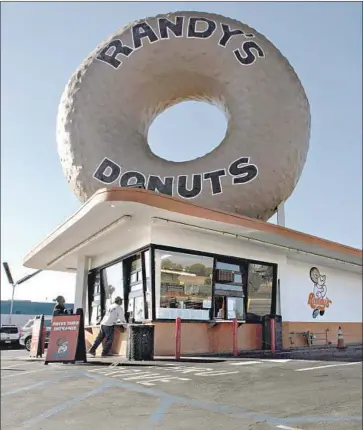  ?? Jason Armond Los Angeles Times ?? THE ORIGINAL Randy’s Donuts sign in Inglewood doesn’t quite f it Costa Mesa planning standards, so owner Mark Kelegian and the city’s planning commission­ers have agreed to seek a suitable compromise.