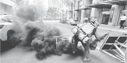  ?? — Gambar Reuters ?? BANTAHAN: Seorang penunjuk perasaan penentang melontar balik kanister gas pemedih mata ke arah polis semasa rali kumpulan Patriot Prayer di Portland, Oregon kelmarin.