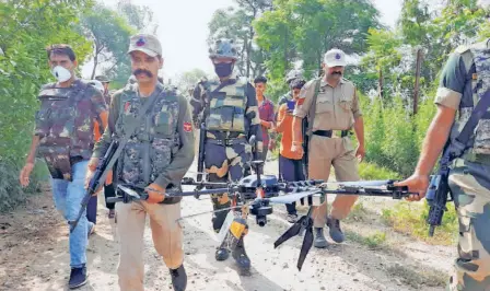  ??  ?? BORDER SECURITY FORCE personnel with a Pakistani drone, loaded with a sophistica­ted rifle and some grenades, which they shot down along the border in Kathua on June 20.