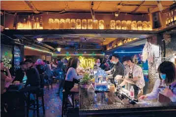  ?? ASHLEY PON/THE NEW YORK TIMES ?? Patrons pack a bar Friday in Taiwan’s capital city of Taipei. The relatively few people allowed to enter the country during the coronaviru­s pandemic have been coming in droves, helping to fuel an economic boom.