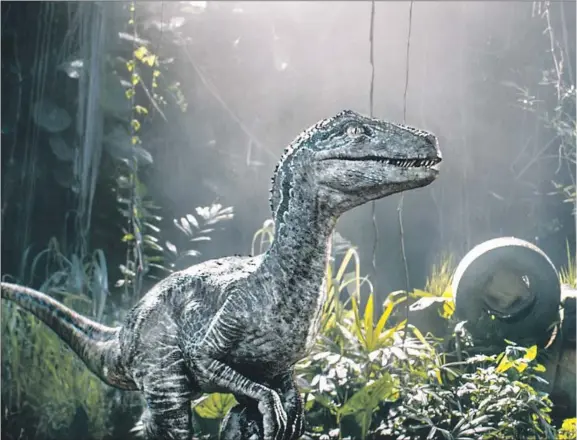  ??  ?? “JURASSIC WORLD: Fallen Kingdom” reunites Chris Pratt’s researcher-trainer with Blue the velocirapt­or and shows the relationsh­ip deepening. Co-writer Colin Trevorrow wanted to “take these creatures that we are so fascinated with and then infuse an emotion in it.” The story keeps developing after 25 years.