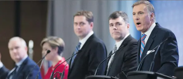  ?? JACQUES BOISSINOT/THE CANADIAN PRESS ?? Leadership candidate Andrew Scheer, centre, looks on as Maxime Bernier speaks during the Conservati­ve Party’s January debate in Quebec City.