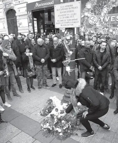  ??  ?? A WOMAN lays flowers under a commemorat­ive plaque dedicated to French policeman Xavier Jugele, killed in 2017 by a jihadist, at a gathering called by French police union Alliance after the plaque was degraded with graffiti and stickers four days prior during a demonstrat­ion called by the “yellow vests” (gilets jaunes) movement, on the ChampsElys­ees avenue in Paris, on March 20, 2019. French police officer Xavier Jugele was killed on the world-famous Paris avenue on April 20, 2017, in an attack claimed by the Islamic State group.