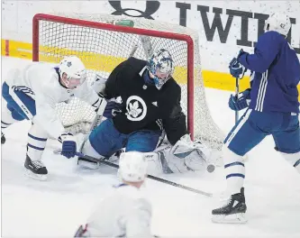  ?? CHRIS YOUNG THE CANADIAN PRESS ?? Maple Leafs goaltender Frederik Andersen makes a stop against centre Tyler Bozak, right, as centre Tomas Plekanec defends during a practice session in Toronto on Monday as the team prepares for its opening playoff round against the Boston Bruins.