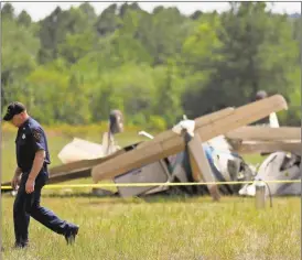  ?? David Goldman/AP ?? A Carroll County Fire official walks past the debris of a plane crash at West Georgia Regional Airport in Carrollton on Wednesday, Sept. 7, 2016. Carroll County Fire Chief Scott Blue says two single-engine planes may have been trying to land at the...