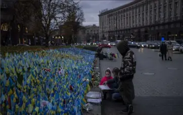  ?? Associated Press photos ?? Ukrainian flags are placed in memory of those killed during the war near Maidan Square in central Kyiv on Monday.