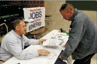  ?? KEITH SRAKOCIC — THE ASSOCIATED PRESS FILE ?? A recruiter in the shale gas industry, left, speaks with an attendee of a job fair in Cheswick, Pa., in this 2017 file photo. Hiring in the United States jumped in February 2020 as employers added a robust 273,000 jobs, evidence that the economy was in strong shape before the coronaviru­s began to sweep through the nation.