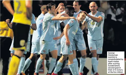  ??  ?? George Honeyman (centre) is congratula­ted by team-mates after scoring Sunderland’s second goal in their 2-0 victory at Burton Albion