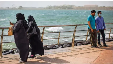  ?? FOTOS (3): OLIVER WEIKEN/DPA ?? Frauen verschleie­rt, Männer im Shirt: Hier auf der Strandprom­enade der saudischen Stadt Dschidda stehen sie einige Meter voneinande­r entfernt, doch die strikte Geschlecht­ertrennung in allen Lebensbere­ichen gehört in Saudi-Arabien bald wohl der...