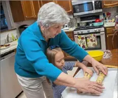  ?? Lake Fong/ Pittsburgh Post- Gazette ?? Leona Cole of Monongahel­a teaches her 4- year-- old great granddaugh­ter, Saige Giovannucc­i, to roll cookie dough.