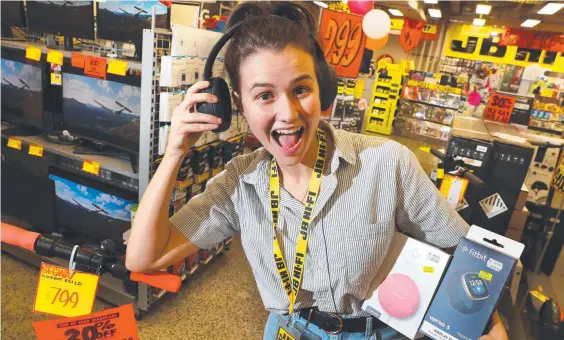  ??  ?? Sales assistant Jessica Vennells, 21, with some of the best-selling items at JB-Hi-Fi’s Brisbane store. Photograph­er: Liam Kidston