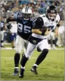  ?? STEPHEN B. MORTON — THE ASSOCIATED PRESS ?? Jaguars quarterbac­k Chad Henne (7) scrambles out of the pocket as he is rushed by Carolina defensive end Charles Johnson (95) during the first half of an NFL preseason football game, Thursday in Jacksonvil­le, Fla.