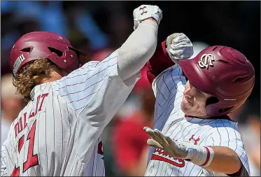  ?? NWA Democrat-Gazette/CHARLIE KAIJO ?? South Carolina infielder LT Tolbert (left) and infielder Justin Row react after Row hit a home run to give South Carolina a 2-1 lead over Arkansas during the bottom of the third inning Sunday in the NCAA Fayettevil­le Super Regional at Baum Stadium. South Carolina went on to win 8-5 to force a third game at 6 p.m. today.