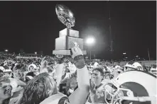  ?? [ALONZO ADAMS/FOR THE OKLAHOMAN] ?? Owasso holds up the gold ball trophy after defeating Jenks in the Class 6A-1 championsh­ip game in Edmond last December.