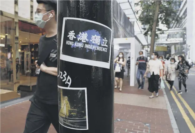  ??  ?? 0 Pro-democracy movement stickers left by protesters in Hong Kong, as police make their first arrests in the territory under new national security laws