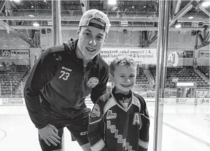  ??  ?? Charlottet­own Islanders goalie Matthew Welsh is shown with his biggest fan, Jack Rodgerson.