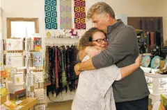  ?? LUKE E. MONTAVON/THE NEW MEXICAN ?? Cindy Cornelsen and Kale Blackmon embrace Friday in their shop, Smash Bangles. The gift store opened seven months ago, but business has been halted after the pair lost their home in a fire.