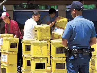  ?? EDD GUMBAN ?? Workers arrange ballot boxes in front of the Las Piñas city hall yesterday. The ballot boxes were distribute­d to designated polling precincts for the elections today.