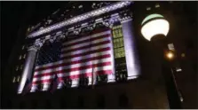  ?? PETER MORGAN — THE ASSOCIATED PRESS FILE ?? An American flag hangs on the front of the New York Stock Exchange on an evening, in New York.