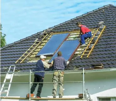  ?? Demontage und Erneuerung von Flachkolle­ktoren einer thermische­n Solaranlag­e in Cottbus Foto: imago/Rainer Weisflog ??