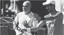  ?? CHRISTOPHE SIMON/AFP/GETTY IMAGES ?? Novak Djokovic, right, talks with his new coach Andre Agassi at a training session ahead of the 2017 French Tennis Open on Friday in Paris. Djokovic has been in a slump.