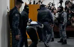  ?? FOTO: ALEKSANDR ZEMLIANITJ­ENKO/AP/TT ?? ■
En av de misstänkta förs in i rättssalen i Moskva på söndagskvä­llen.