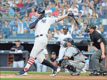  ?? / AP-Frank Franklin II ?? New York Yankees’ Aaron Judge follows through on a home run during the first inning of a baseball game as Atlanta Braves catcher Kurt Suzuki, center, and home plate umpire Mike Estabrook watch July 2 in New York.