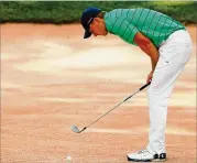  ?? KEVIN C. COX / GETTY IMAGES ?? Jordan Spieth sizes up a bunker shot at the 17th hole during his round of par 70. Cup points leader Spieth is four back going into the weekend.