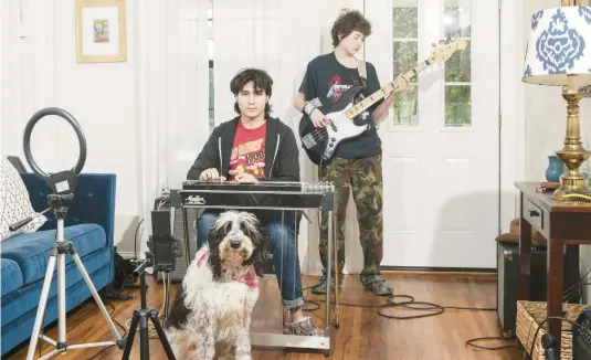  ?? ELI DURST/THE NEW YORK TIMES PHOTOS ?? Noah Faulkner practices with his pedal steel guitar at home with his brother, Nate, on bass and their dog, Kara, on March 18 in Austin, Texas.