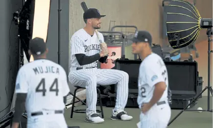  ?? Andy Cross, The Denver Post ?? Rockies outfielder Sam Hilliard, center, poses for Rockies team photograph­er Matt Dirksen (not pictured) on photo day at Salt River Fields at Talking Stick on Thursday.