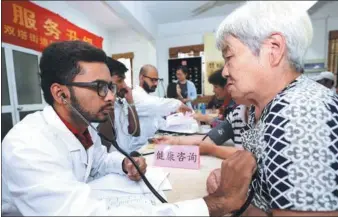  ?? XU ZHIQIANG / FOR CHINA DAILY ?? Palsana Kishan, an Indian medical student at the Medical College of Soochow University, checks an elderly woman at a community in Suzhou, Jiangsu province, on Monday. He and his associates volunteere­d to provide health consultati­ons and give insights...