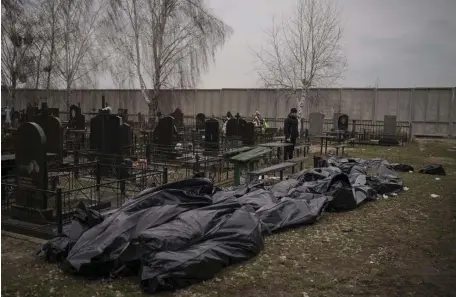  ?? Ap pHOTOs ?? GRISLY ACTS: Dozens of bodies wait to be buried at a cemetery in Bucha, a city on the outskirts of Kyiv. Below, Ukrainian President Volodymyr Zelenskyy, on screen, appeals to lawmakers in Spanish parliament on Tuesday.