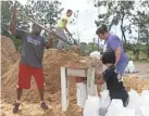  ??  ?? From left, Haskel Johnson, Daniel Tippett, Jennifer Tippett and Nobuko Johnson fill sand bags Monday in Lynn Haven, Fla.