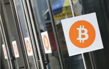  ?? AP ?? Bitcoin logos displayed at a recent Inside Bitcoins conference in New York. It’s worth more than an ounce of gold right now. Numerous alternativ­e cryptocurr­encies, or ‘altcoins’ such as ripple, have emerged since bitcoin broke into the public...