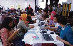  ??  ?? JAKARTA: In this photograph taken on September 30, 2016, Indonesian­s report their tax figures on the last day of the tax amnesty first round program. —AFP