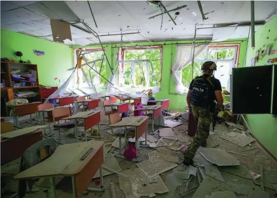  ?? REUTERS ?? Un soldado revisa un colegio alcanzado por un bombardeo ruso